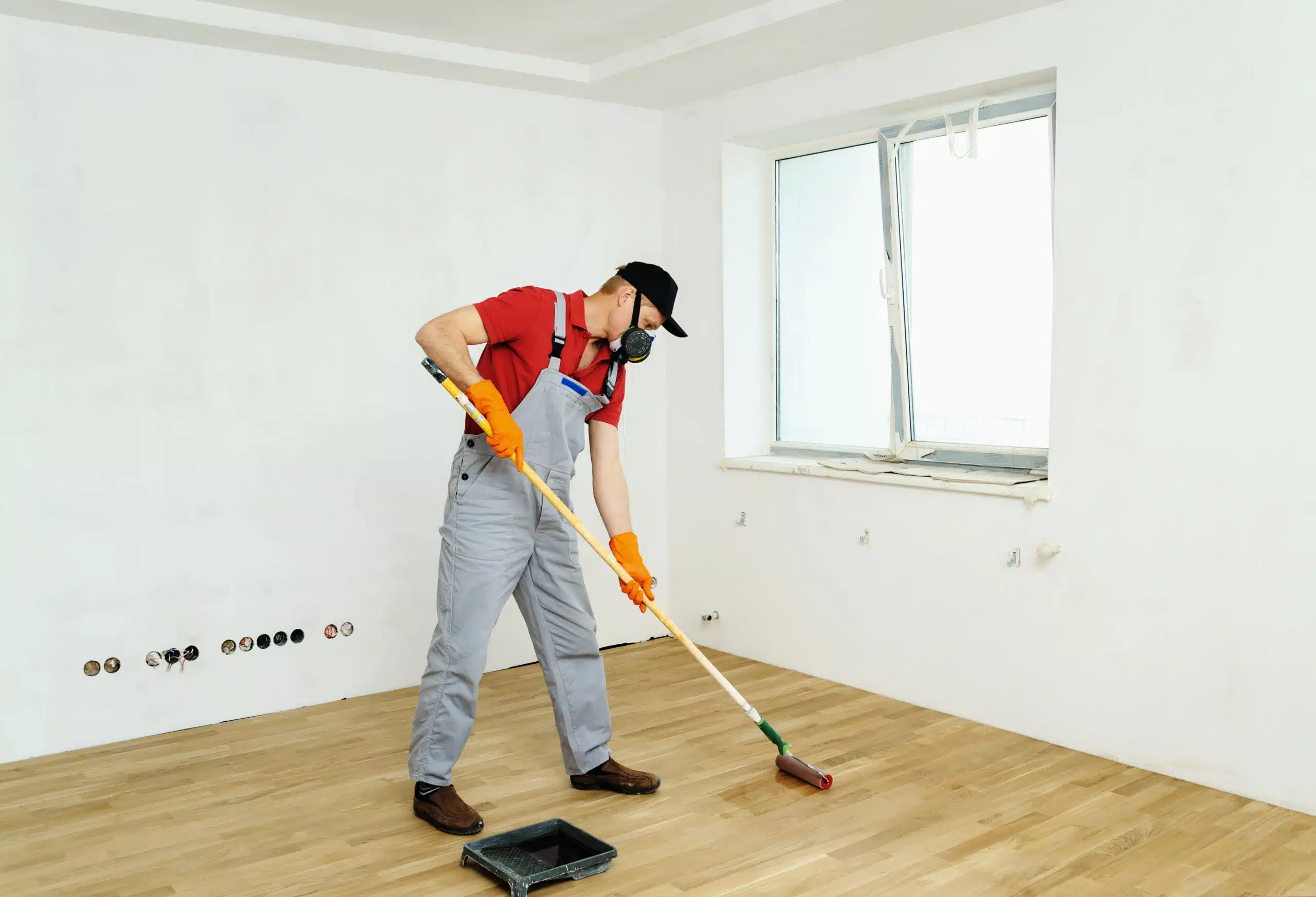 contractor painting a non-slip coating on a laminated floor