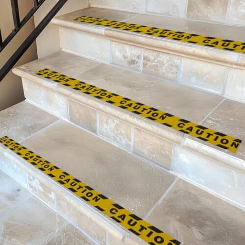 Anti Slip tape on the edge of a stair with the word caution printed onto the tape
